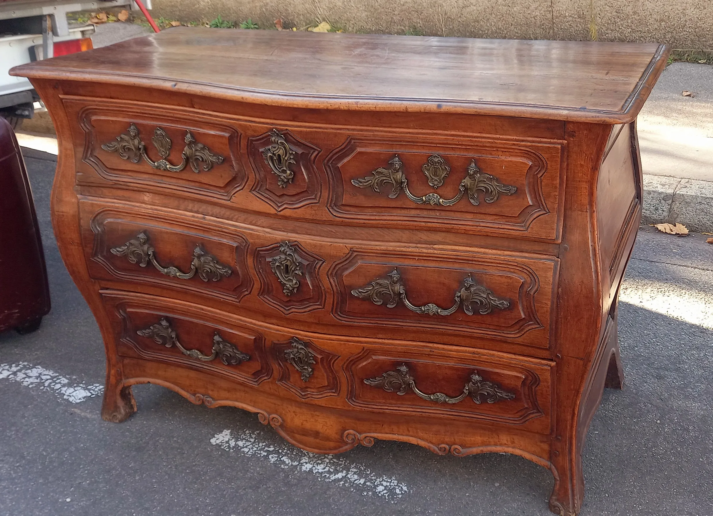 Commode galbée en bois à poignées de bronze ouvragées