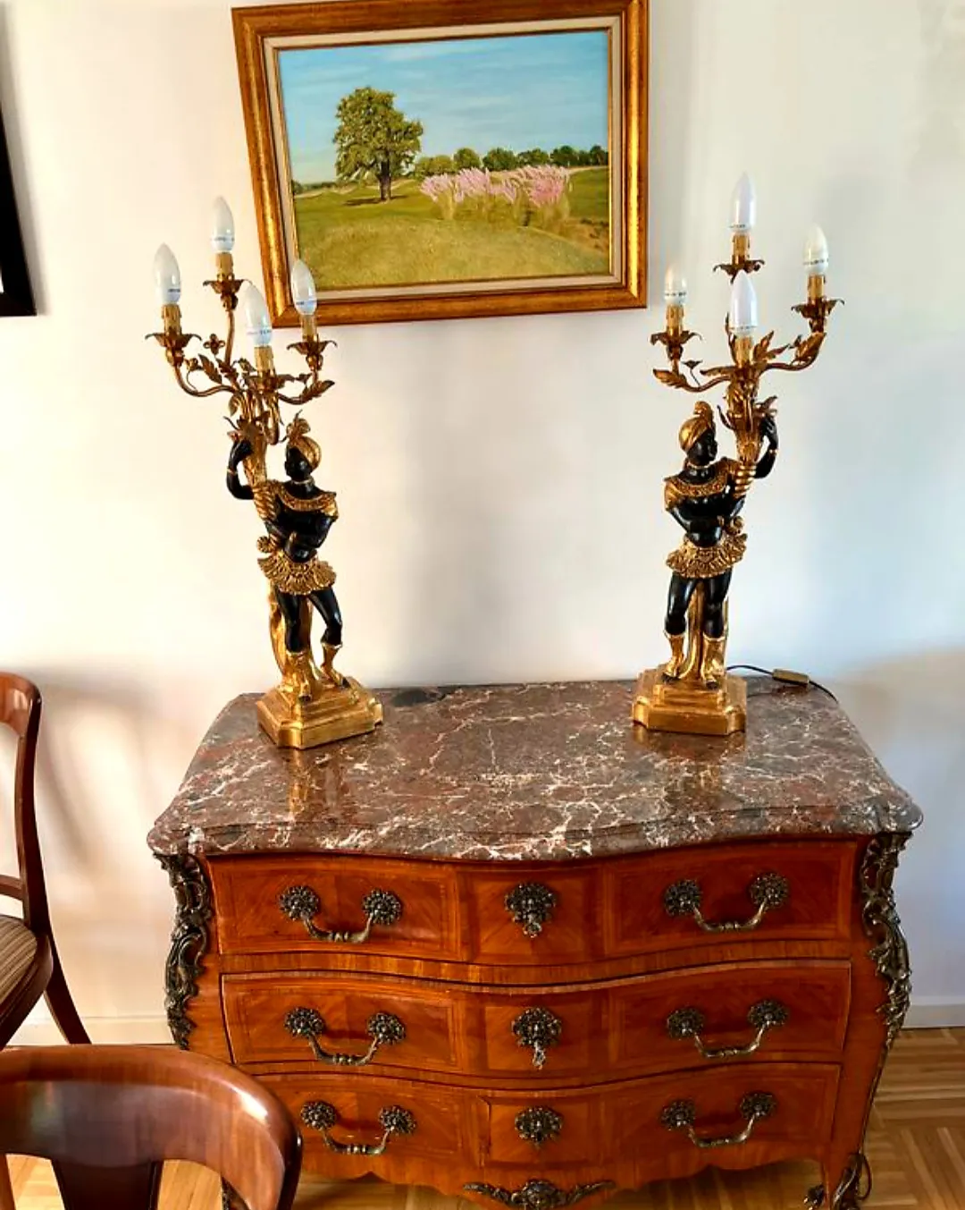Commode galbée à plateau de marbre rouge, surmontée de deux candélabres dorés